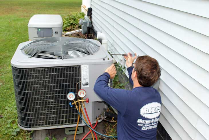 Image of service tech working on air conditioning unit